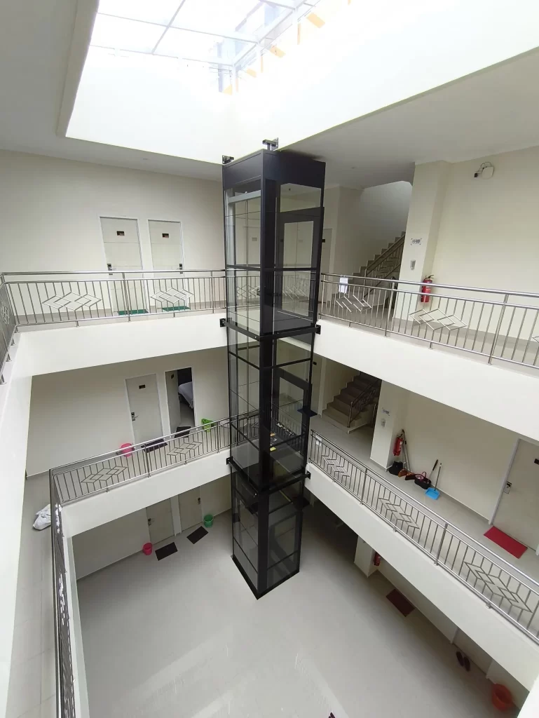 Lift rumah Kalea X80 dengan shaft kaca di area void bangunan bertingkat