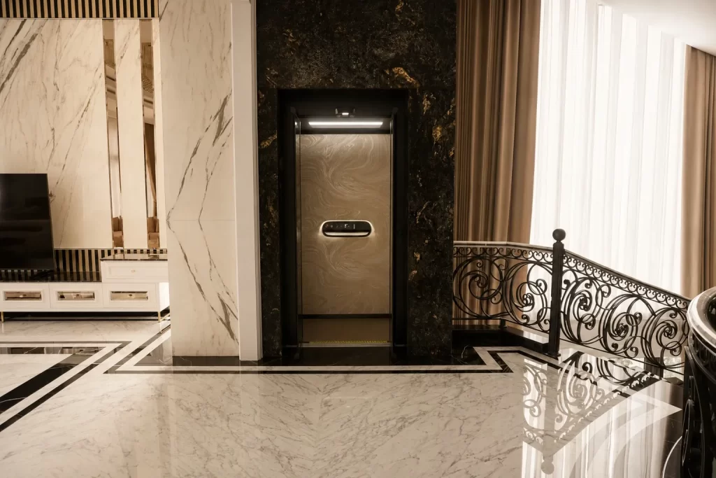 Checklist Pasang Lift Rumah: 15 Hal Penting 11 Pintu Kalea home lift dengan finishing marmer gelap di lantai atas